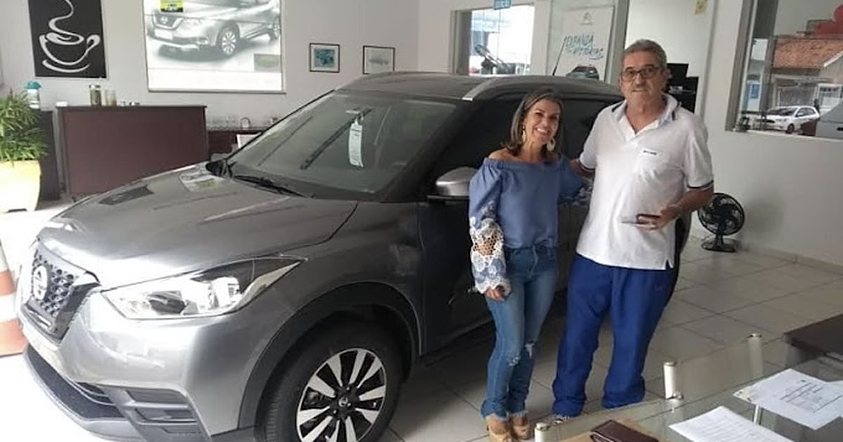 Pessoa fazendo as contas da economia da isenção PCD com a chave de um carro 0km sobre a mesa